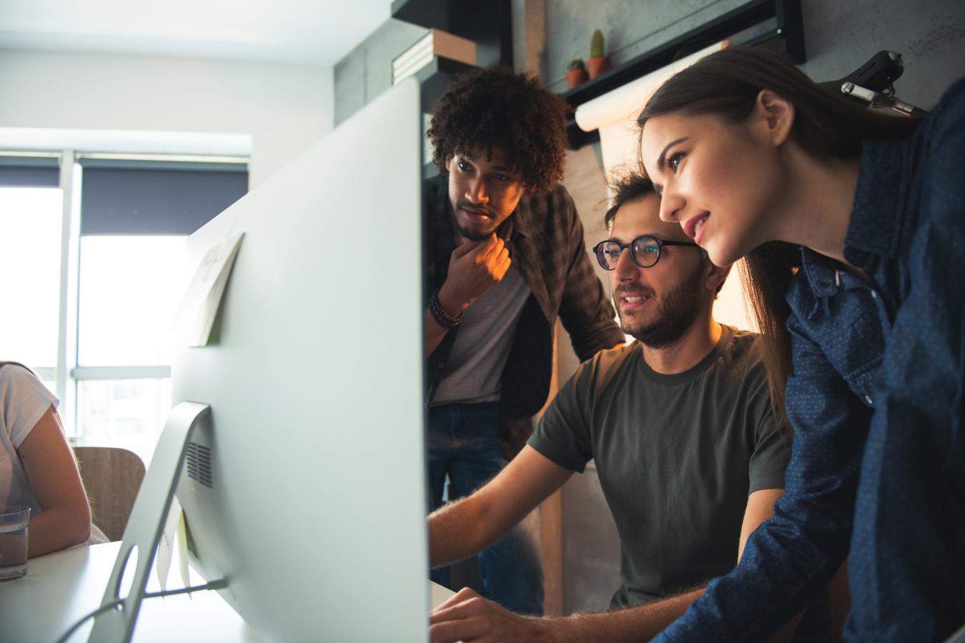 Three individuals focused on IT Security content displayed on a computer monitor for a variety of industries.