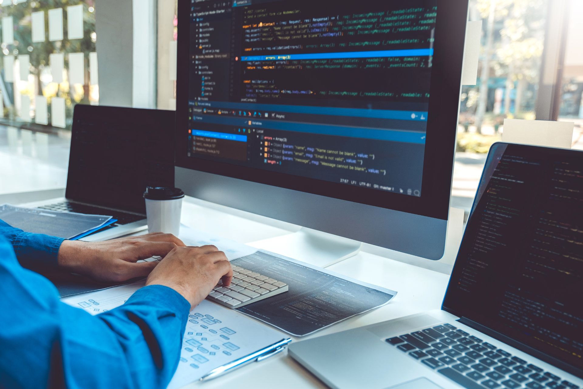 A technician programming on multiple computers providing RamcoTek IT consulting services.