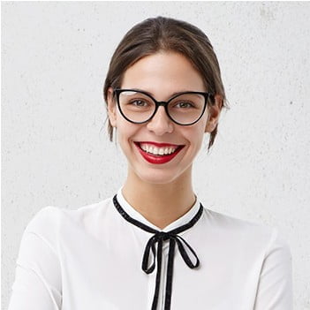 Smiling woman with glasses wearing a white blouse with a black tie detail.